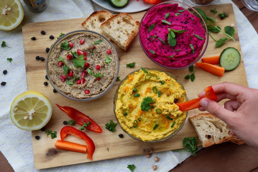 Hummus trio platter featuring three signature hummus flavors