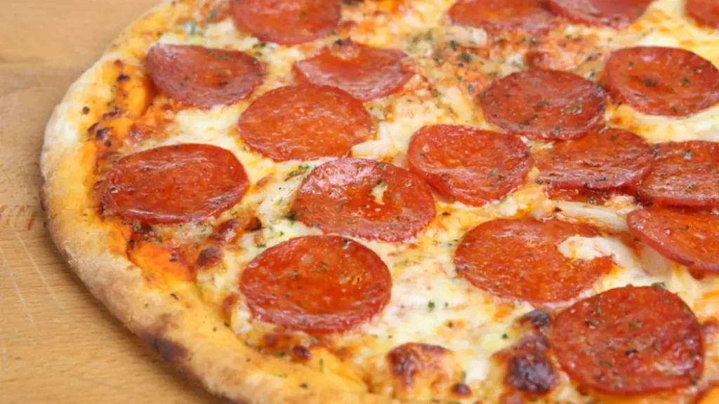 Pepperoni pizza with melted cheese at Mezzaluna Jamaica